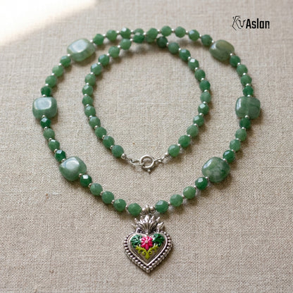 Collar Corazón Milagro Verde sobre superficie